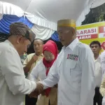 Calon Gubernur Kaltim Isran Noor memakaikan seragam relawan Isran-Hadi kepada Daeng Tunru pada Senin malam (14/10/2024).