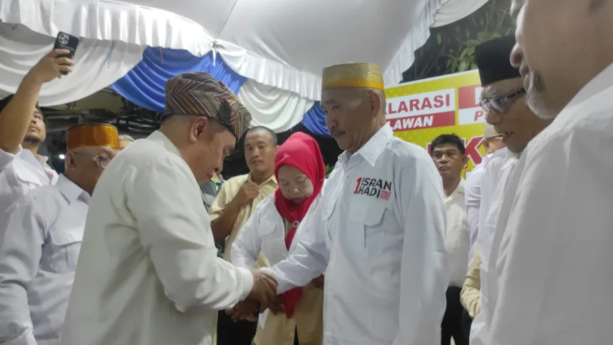 Calon Gubernur Kaltim Isran Noor memakaikan seragam relawan Isran-Hadi kepada Daeng Tunru pada Senin malam (14/10/2024).